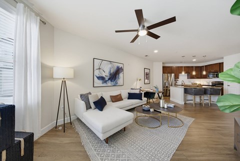 A living room with a white couch and a ceiling fan.