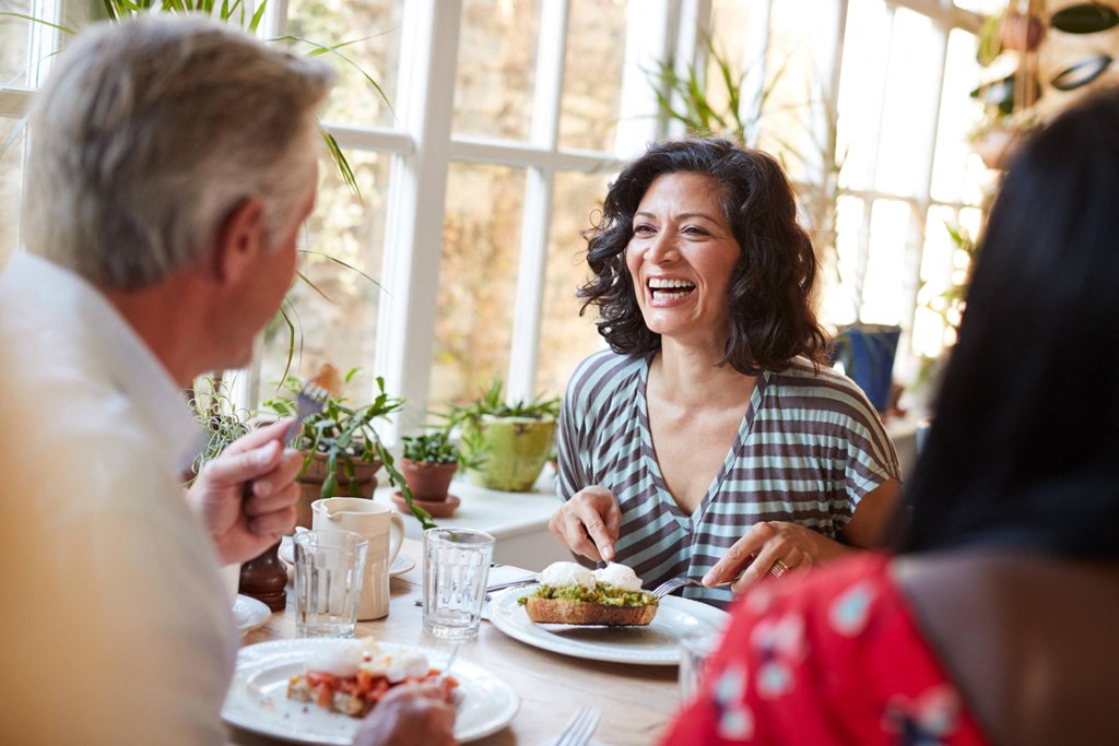 a group of people sitting around a table eating food