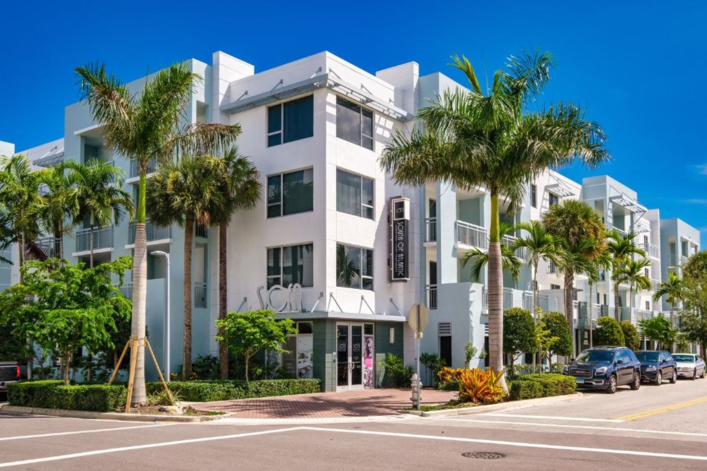 a building with palm trees in front of it on a street