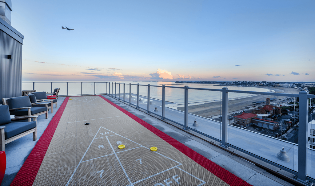 A shuffleboard court on a balcony with a view of the city.