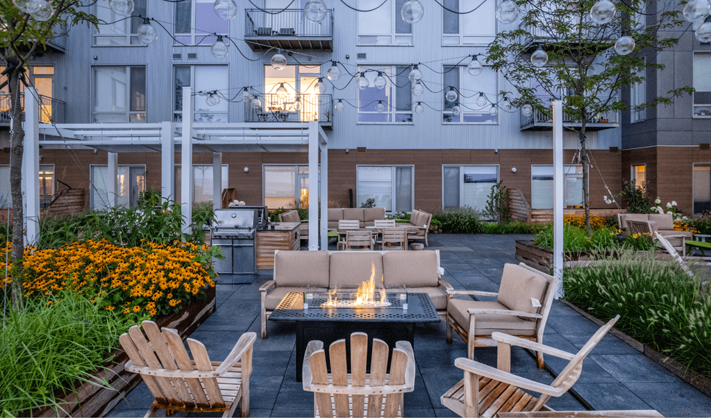 A patio with chairs and a fire pit.