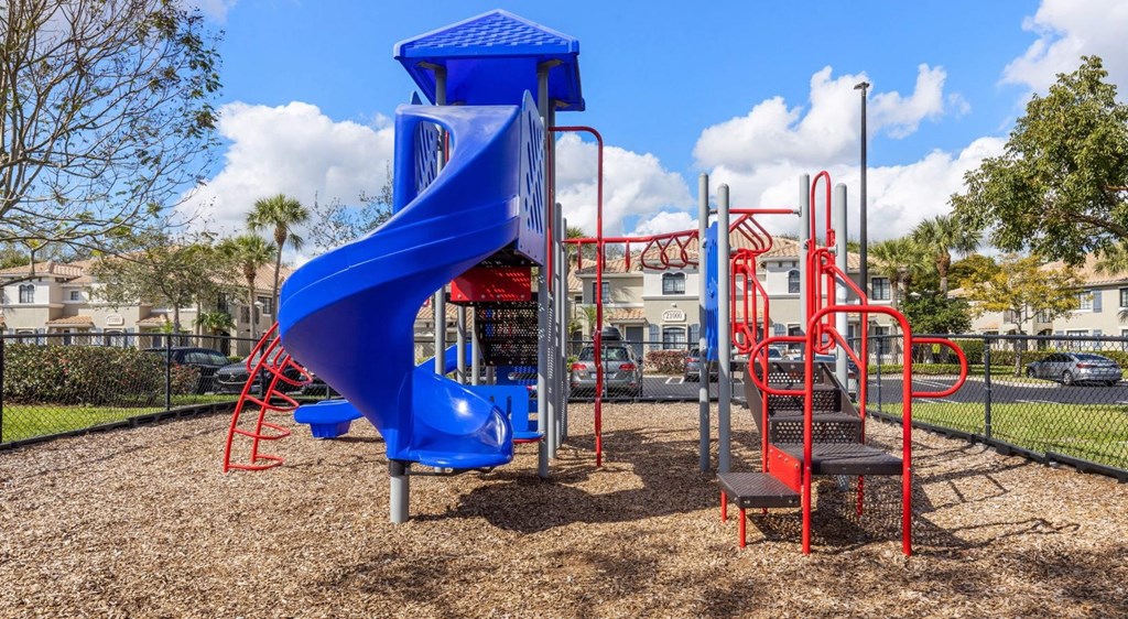 A playground with a blue slide and red climbing structures.