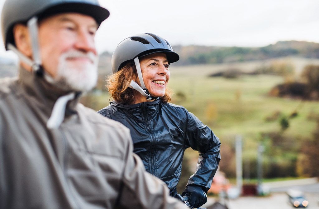 a man and a woman wearing helmets talking on a cell phone