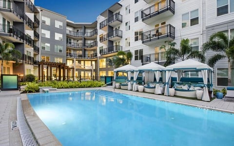 Evening Poolside Scene with Private Cabanas and Soft Courtyard Lighting