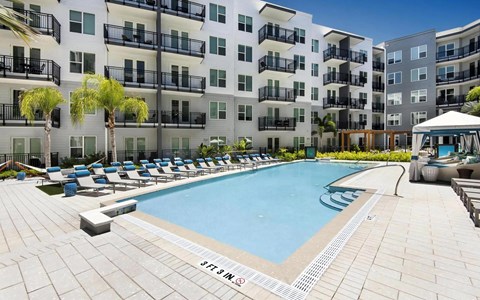 Sunny Pool Area with Comfortable Seating and Poolside Cabanas