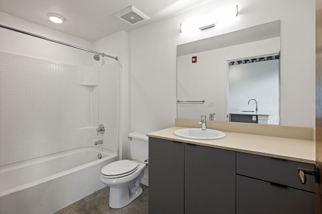 A white toilet sits next to a bathtub in a bathroom.