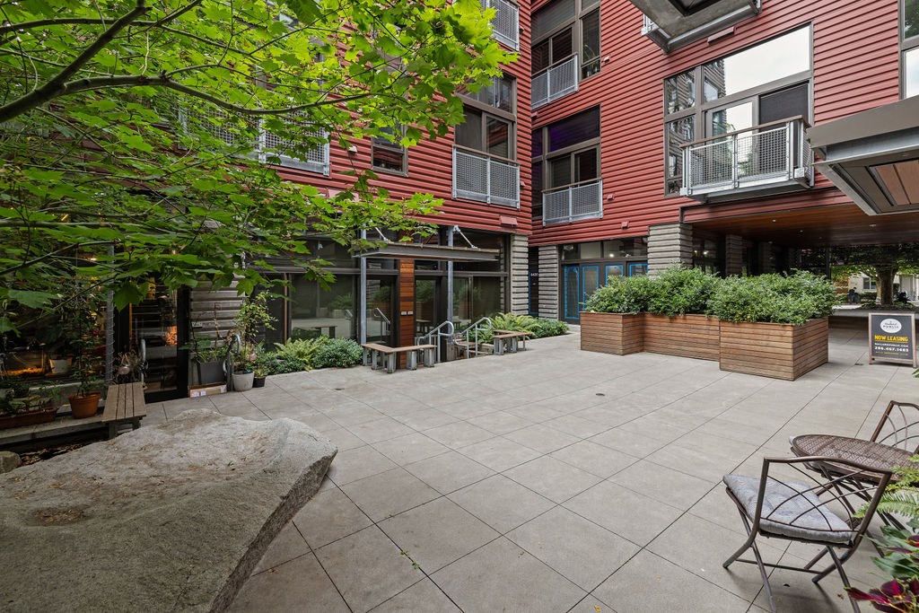 A courtyard with a table and chairs surrounded by buildings.