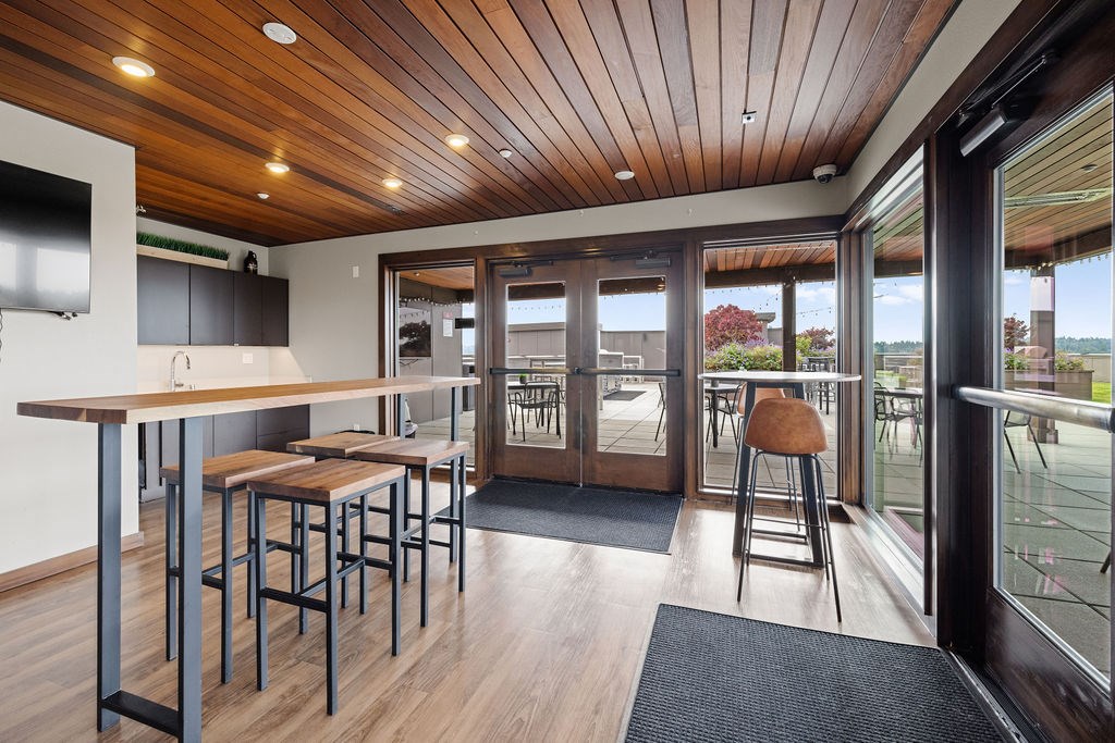 A modern kitchen with a bar area and sliding glass doors.