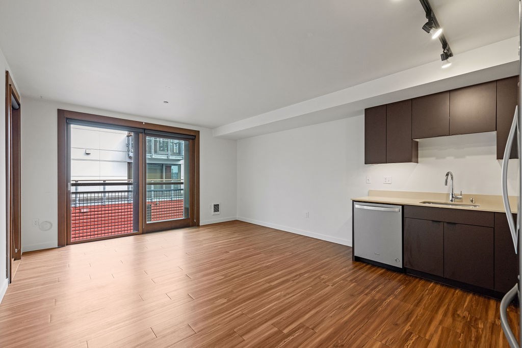 A kitchen area with a sink and a refrigerator.