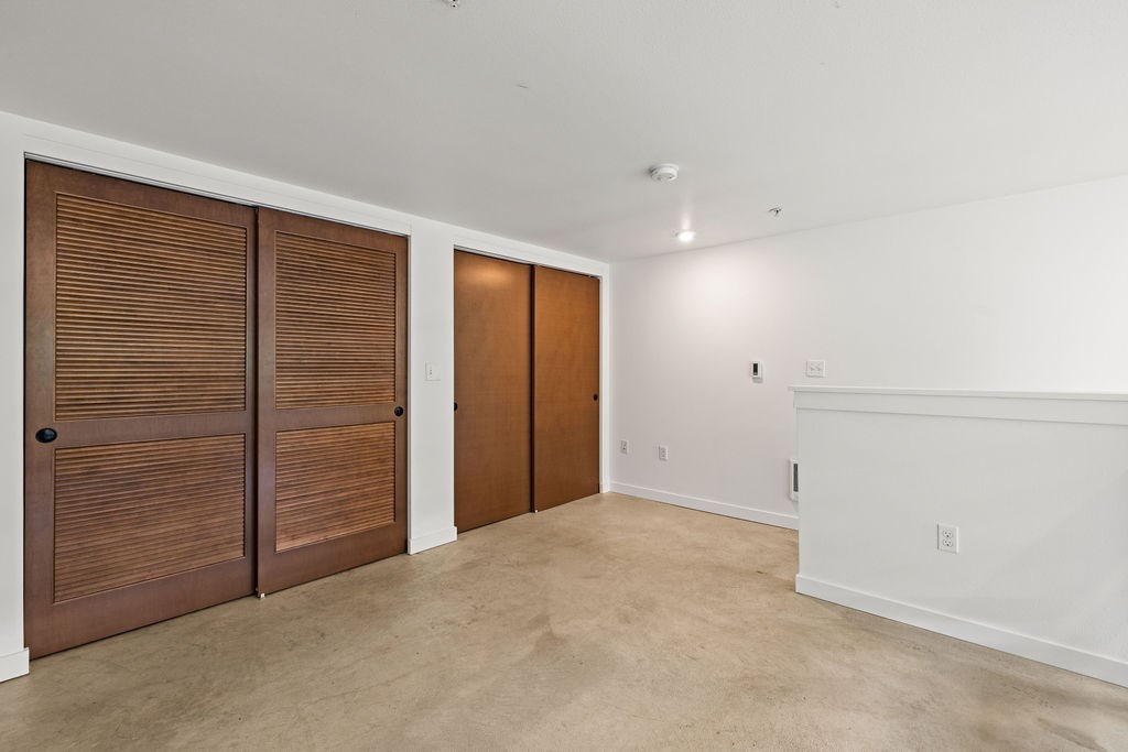 A room with two brown doors and a white wall.