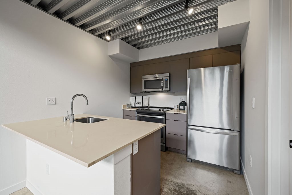 A kitchen with a sink, stove, and refrigerator.