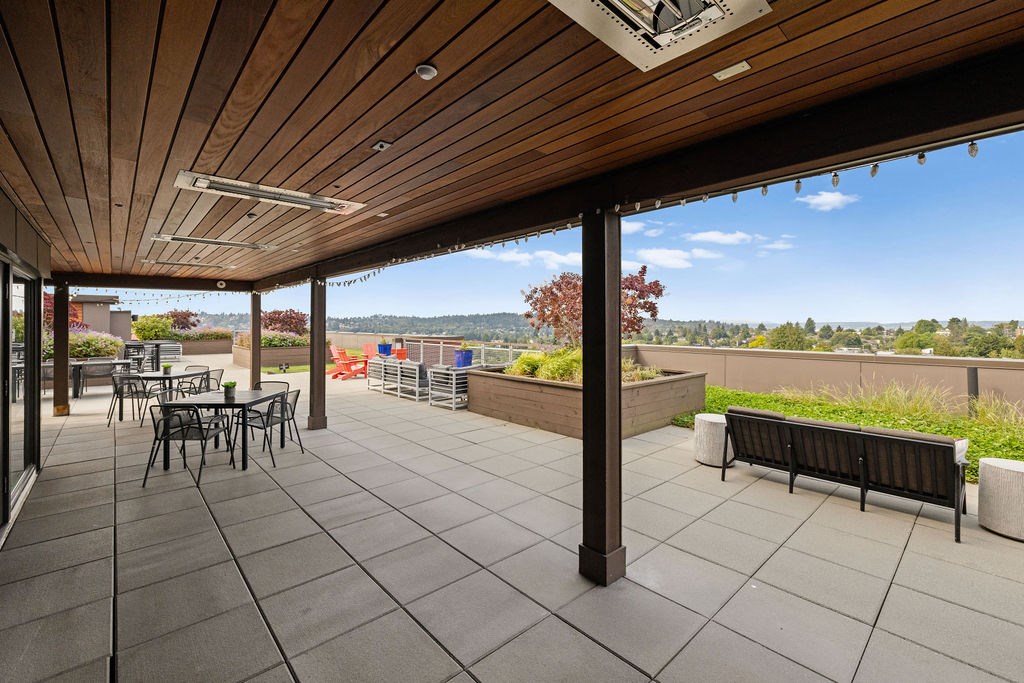 A patio with a table and chairs and a bench.