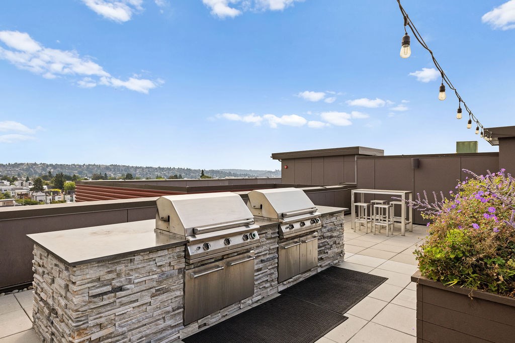 A stone outdoor kitchen with a grill and a table.