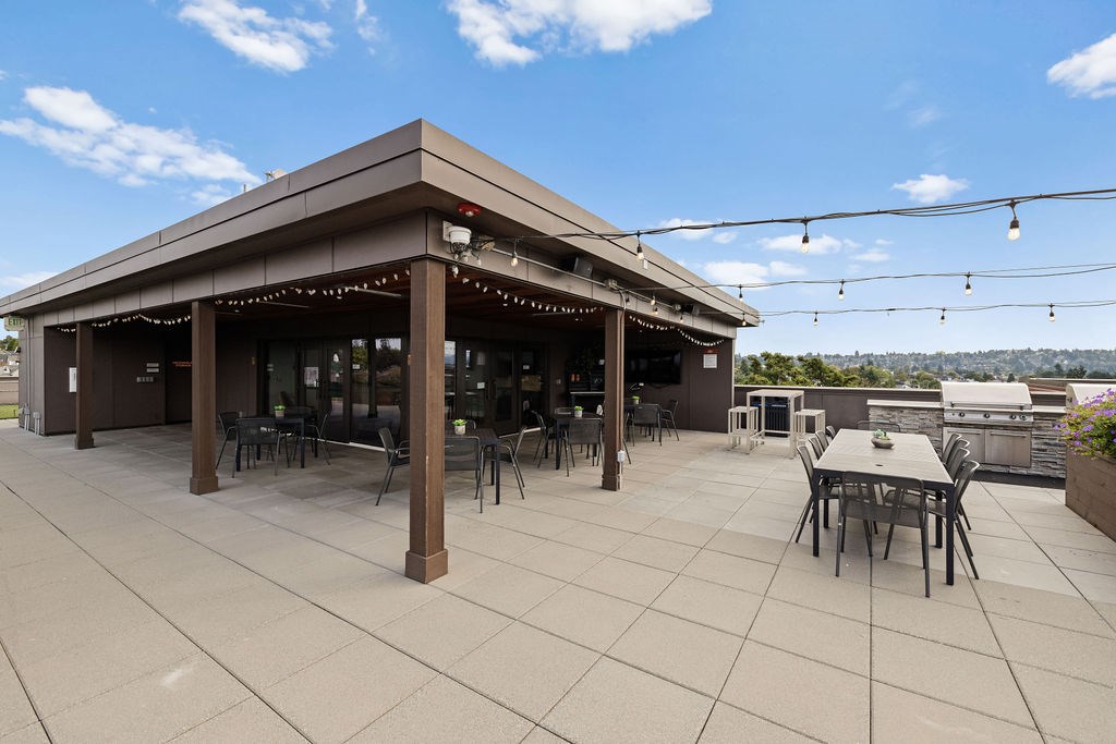 A patio with a table and chairs under a roof.