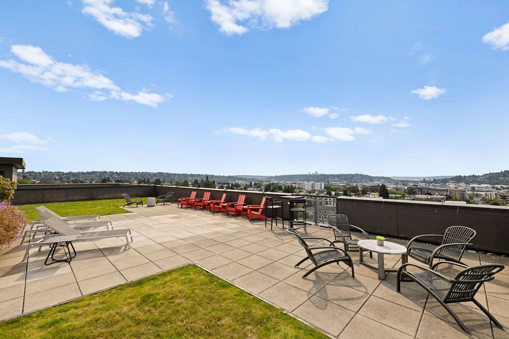 A patio with a table and chairs overlooking a city.