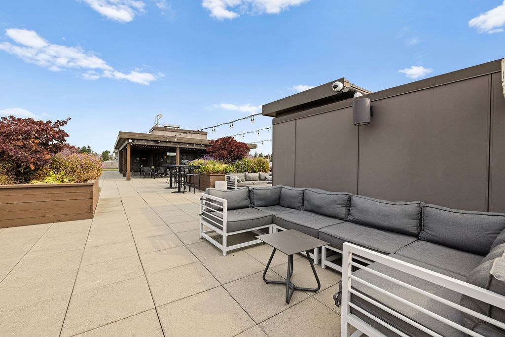 A patio with grey couches and a table.