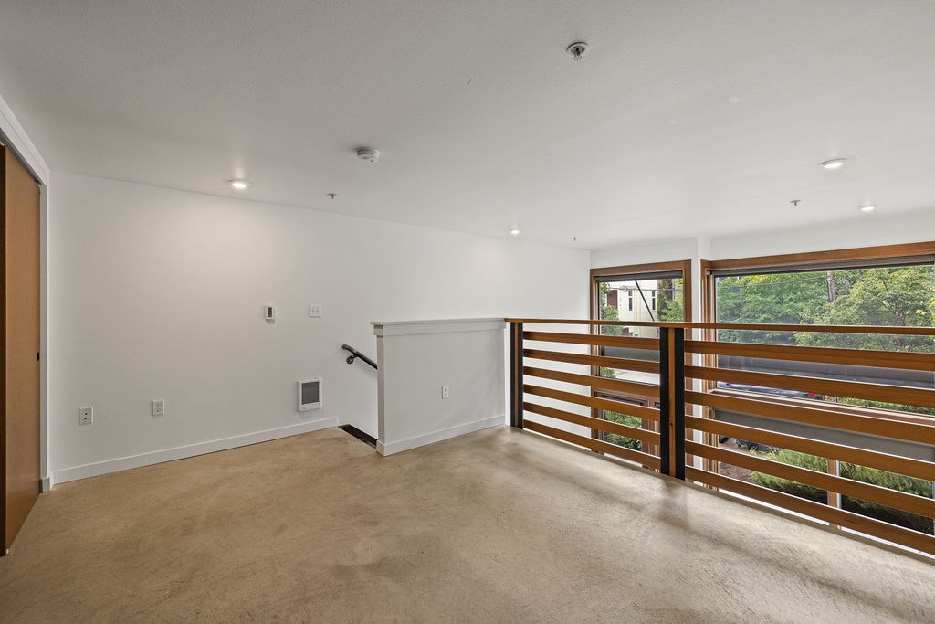 A room with a sliding door and a window with a view of trees.