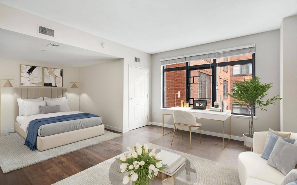 Apartment Interior Showing Sleeping Area, Desk, and Urban Window View