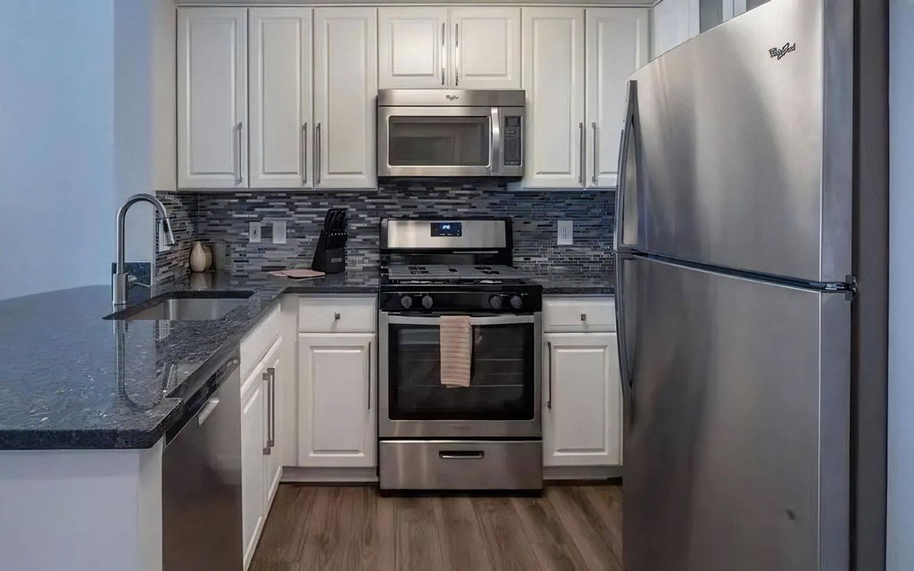 U-Shaped Kitchen With Stainless Steel Appliances and Granite Countertops