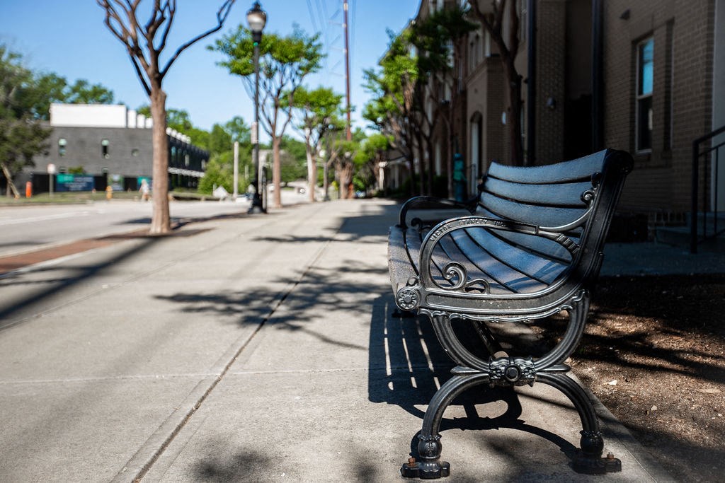 a bench on a sidewalk on a city street