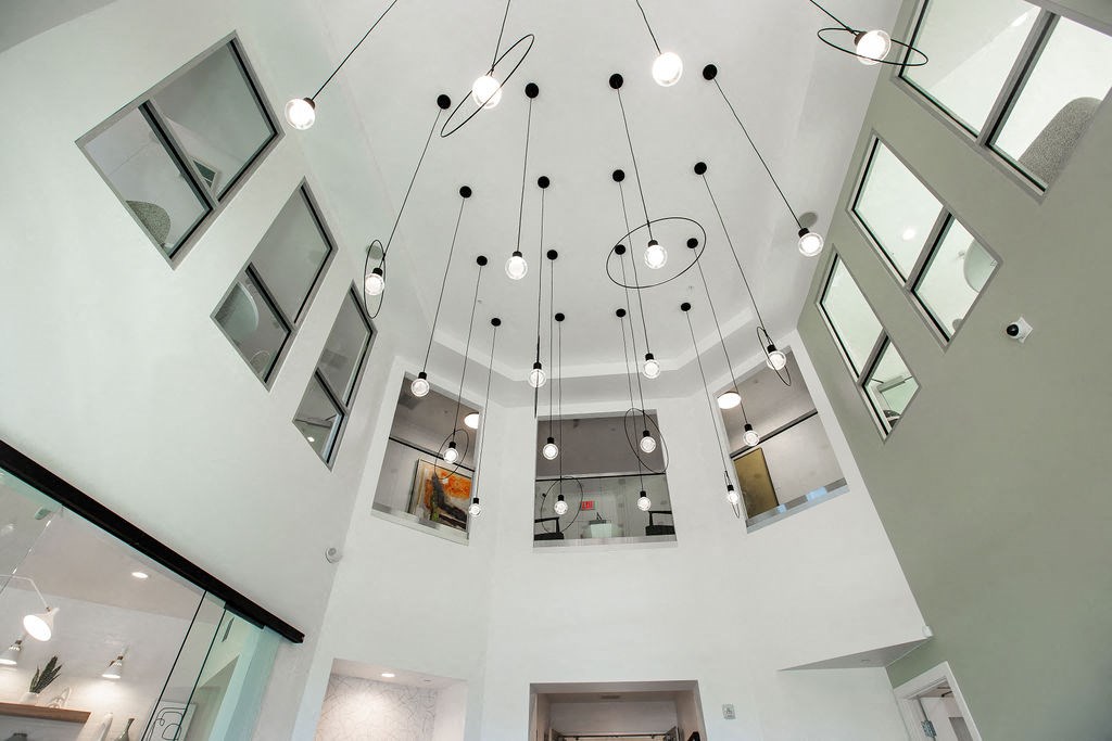 a view from the second floor looking up into the ceiling filled with light fixtures