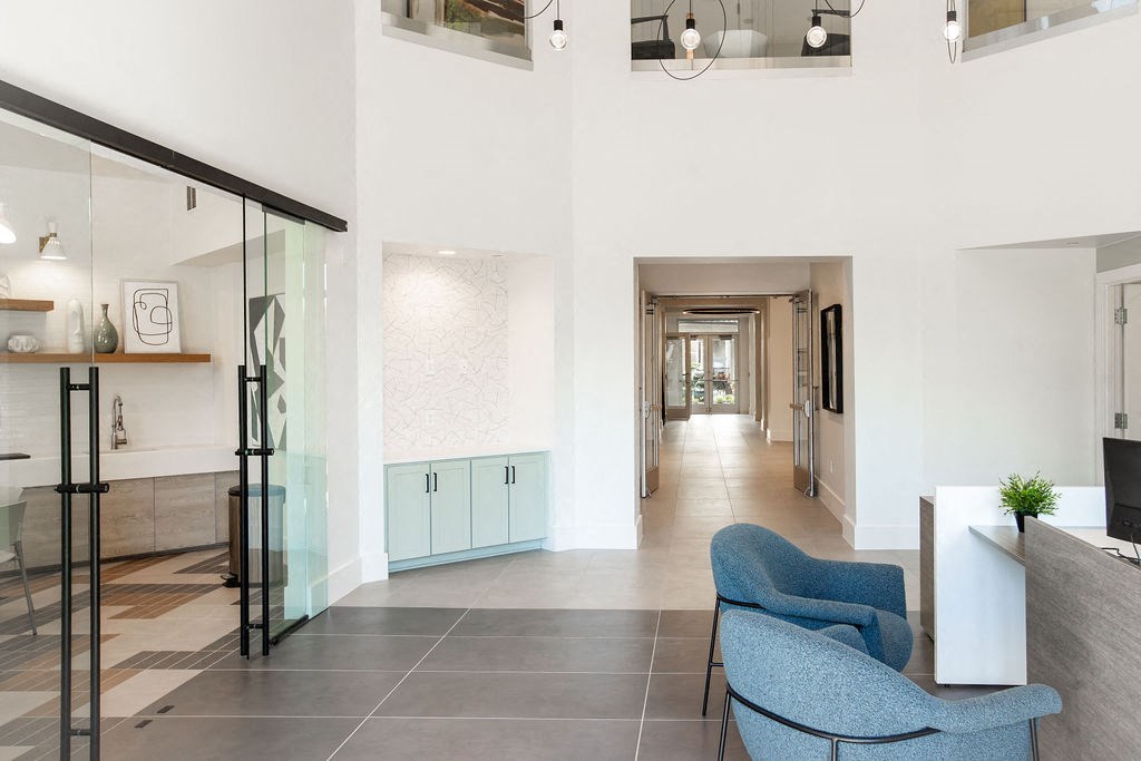 the lobby or reception area of a hotel with blue chairs