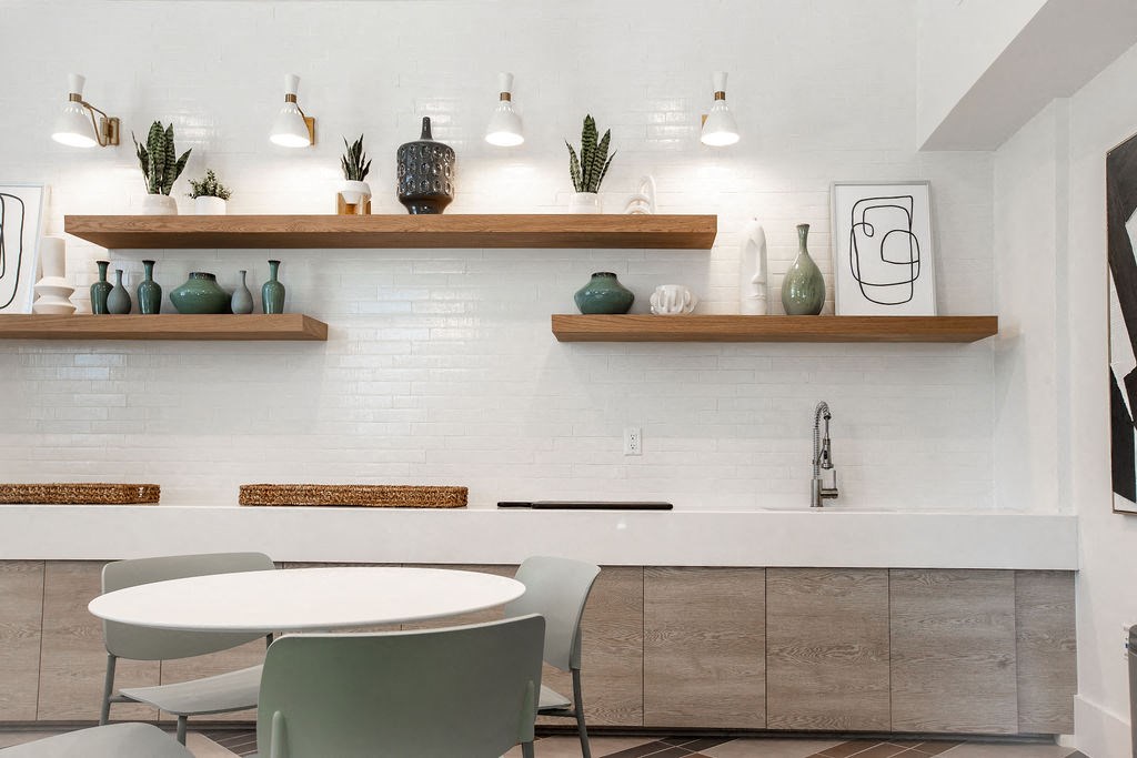 a white kitchen with a table and chairs and shelves