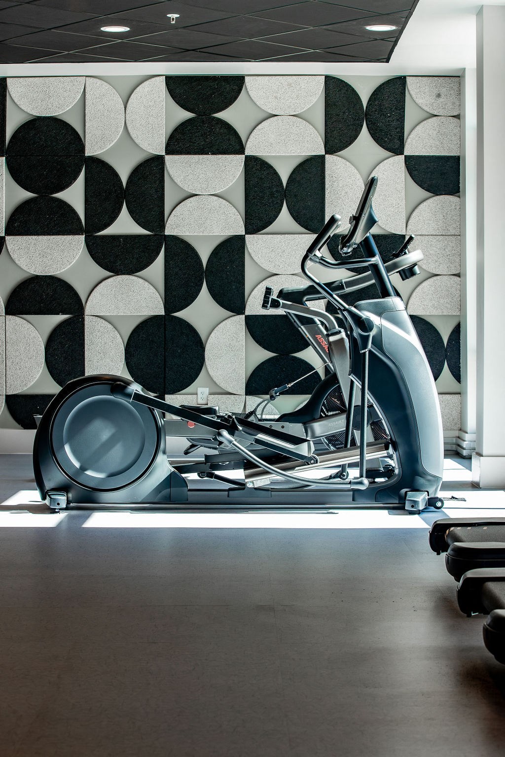 a gym with a workout machine in front of a tiled wall