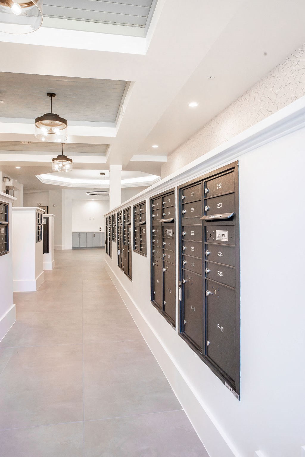 a long corridor with lockers and a white wall with a ceiling light and a