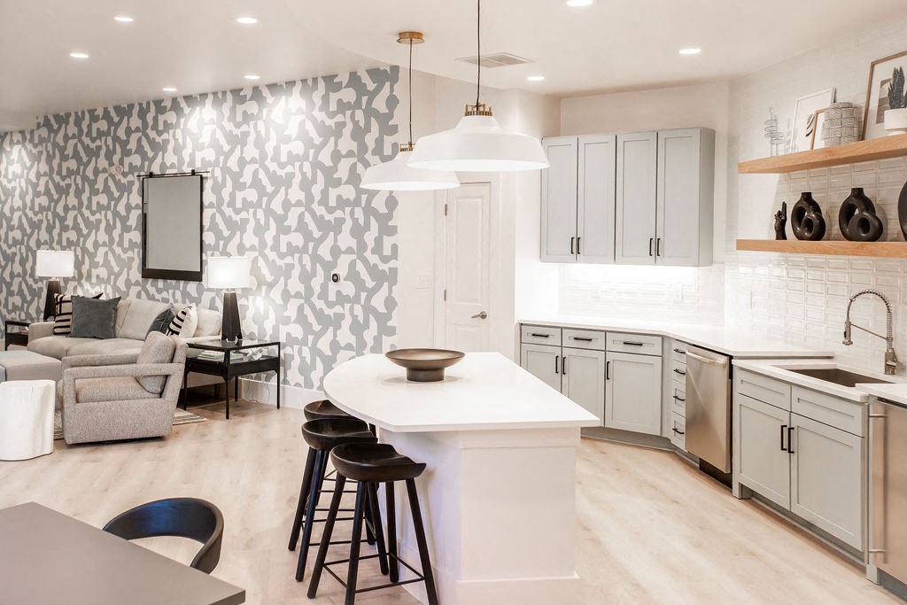 a kitchen with a white counter top and a living room