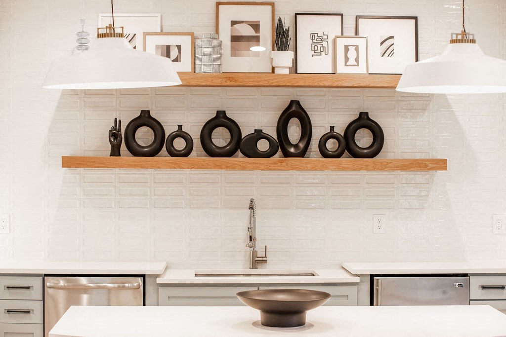 a kitchen with white counter tops and a shelf with plates on it