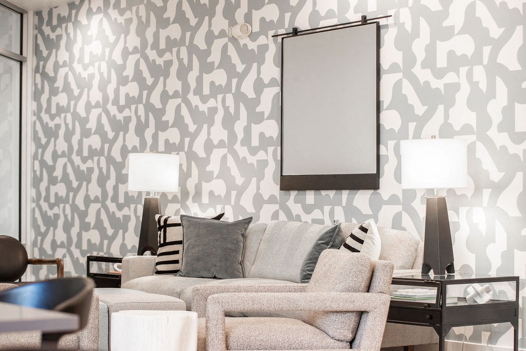 a living room with a couch and chairs and a wallpaper