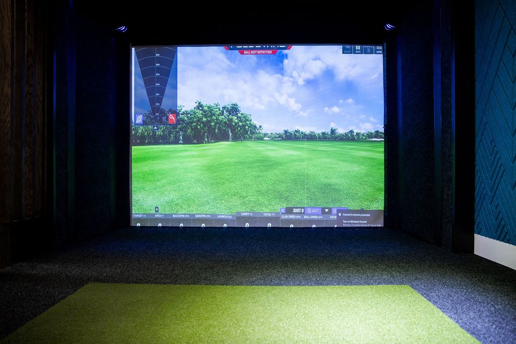 a large screen with a view of a field on a golf course