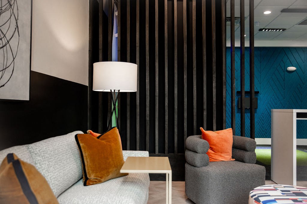 a living room with a couch and chair and a lamp