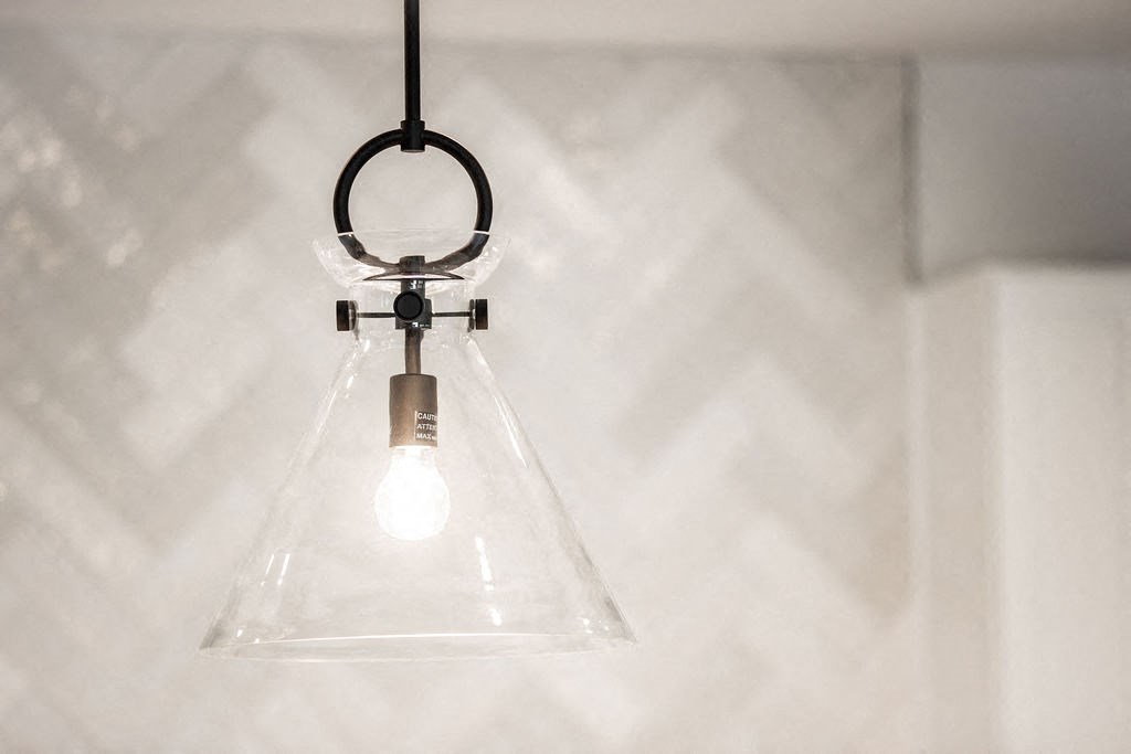 a lightbulb hanging from a ceiling with a clear plastic lamp shade