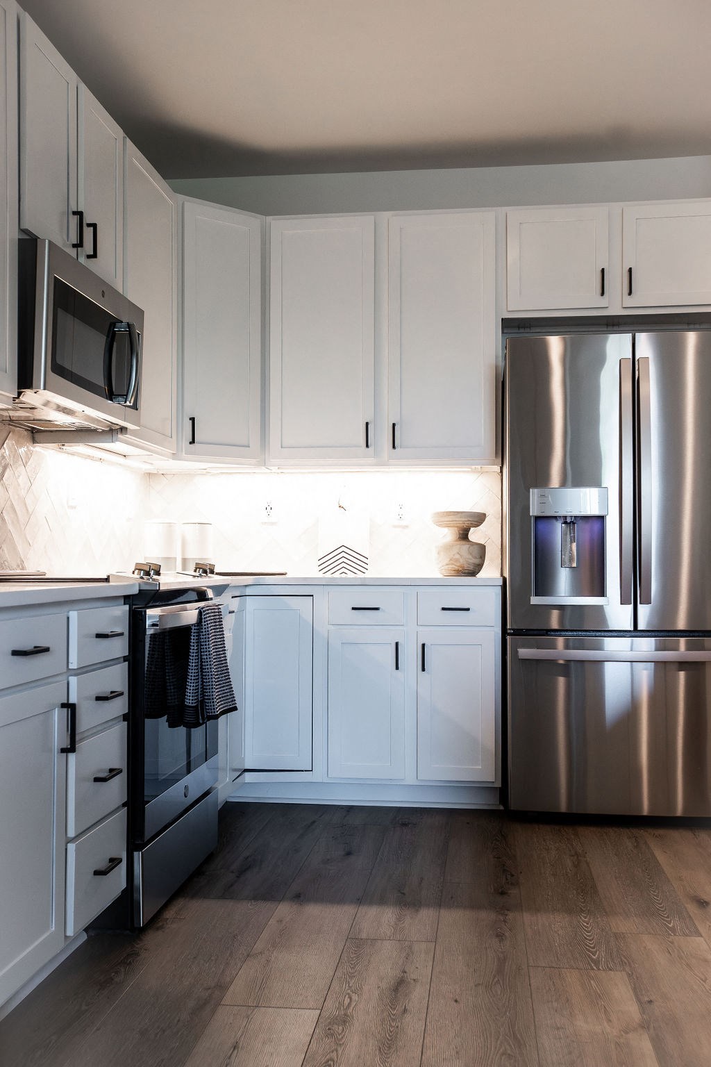 a white kitchen with stainless steel appliances and white cabinets