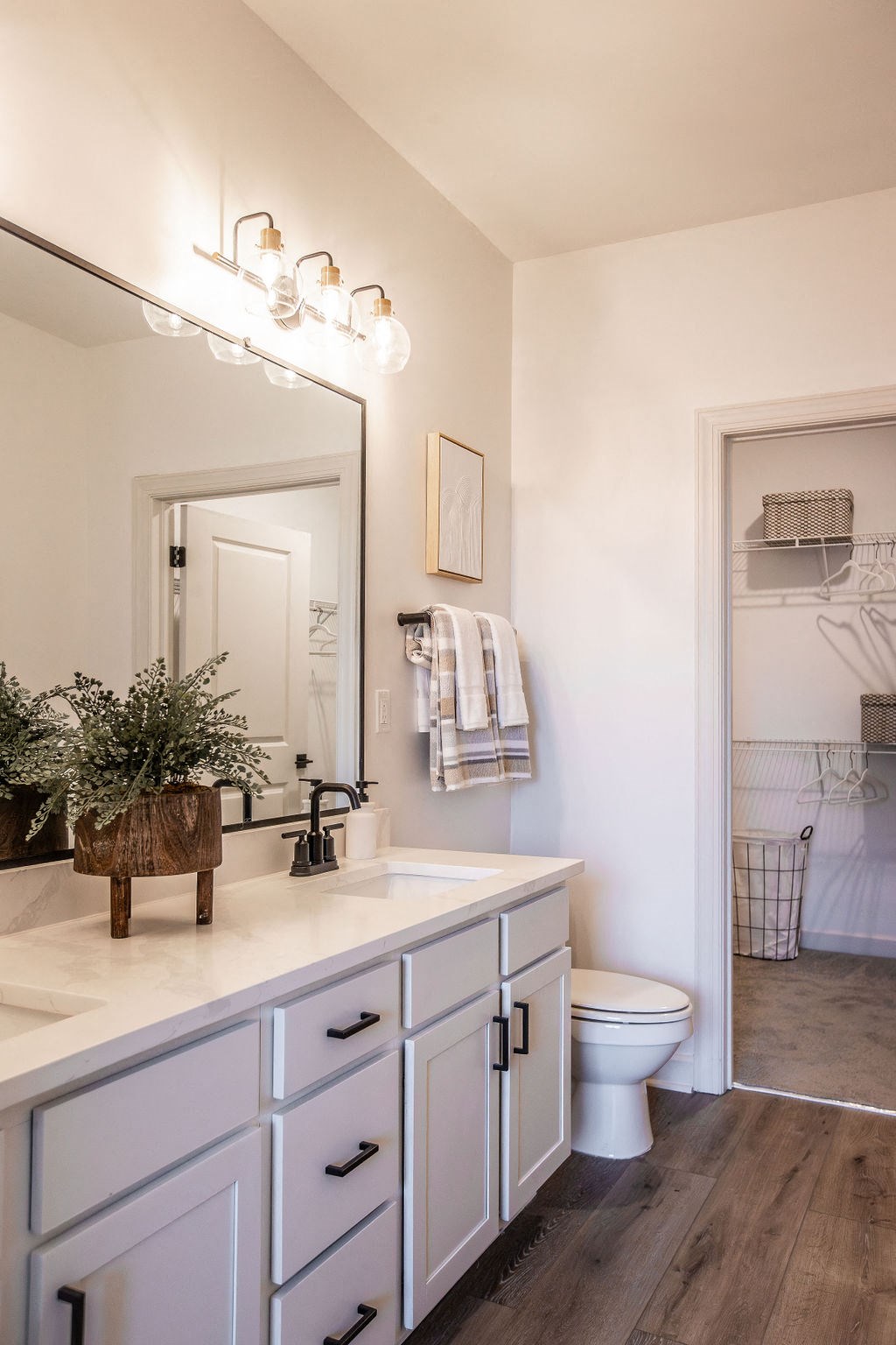 a white bathroom with a large mirror and a toilet