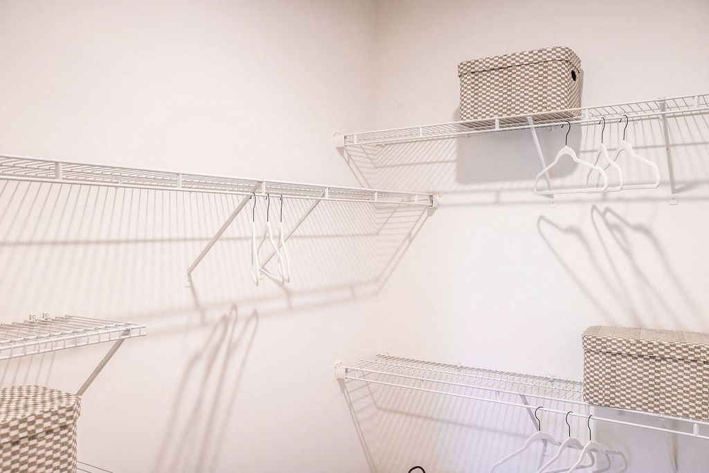 the walk in closet with metal baskets and shelves