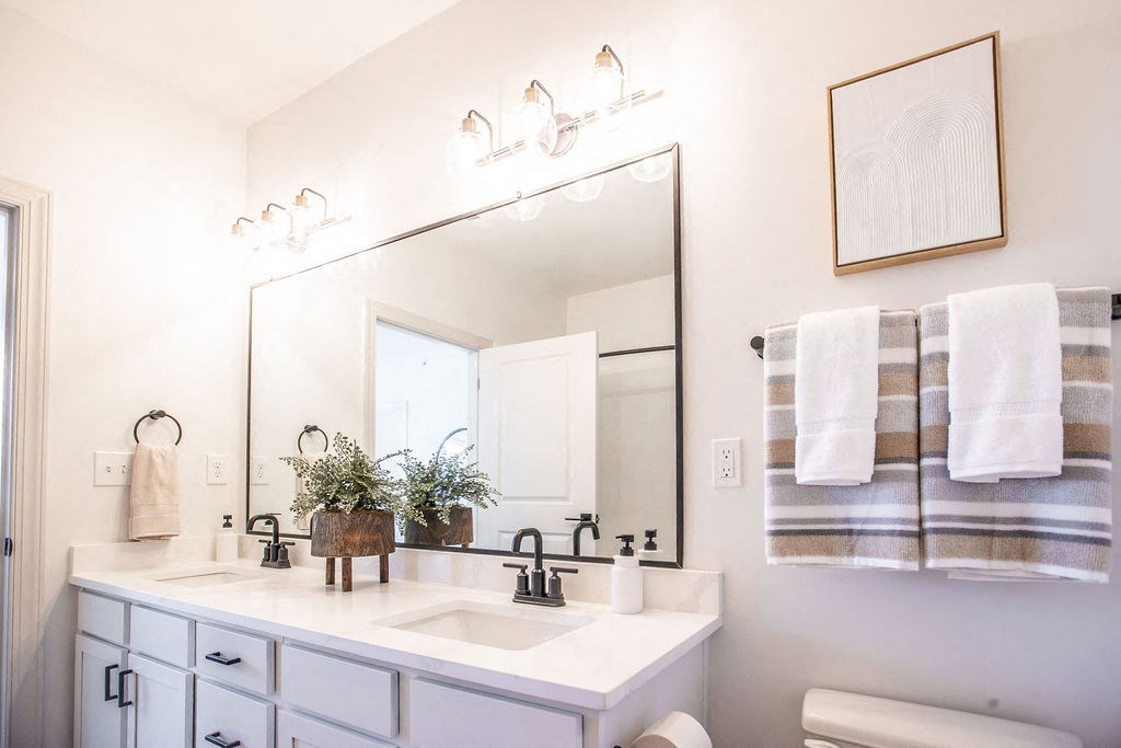 a white bathroom with a large mirror and a sink