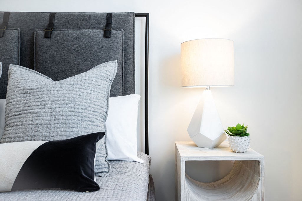 a bedroom with a bed and a night stand with a lamp
