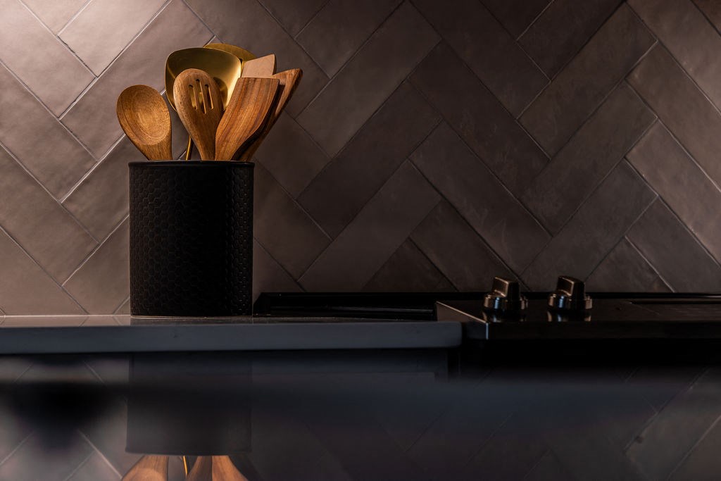 a bunch of wooden spoons in a black cup on a table