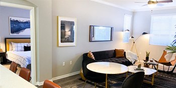 Apartments for Rent Rancho Cucamonga CA - The Angelica - Modern Living Room with White Walls, Wood-Style Flooring, and Windows - Photo Gallery 5
