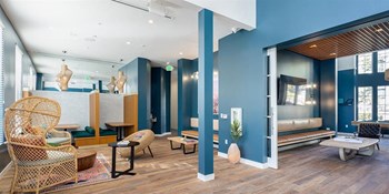 Apartments Rancho Cucamonga CA - The Angelica - Building Lobby with Blue Walls, Orange Accent Furniture, and Seating - Photo Gallery 2