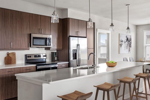 A modern kitchen with wooden cabinets and a white countertop.