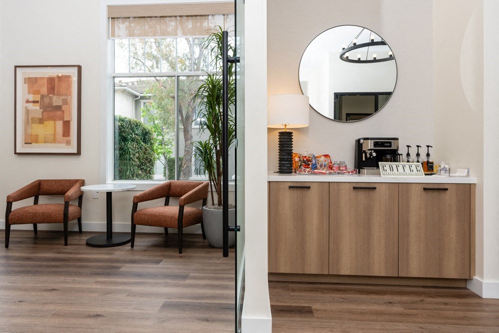 a living room with a table and chairs and a mirror
