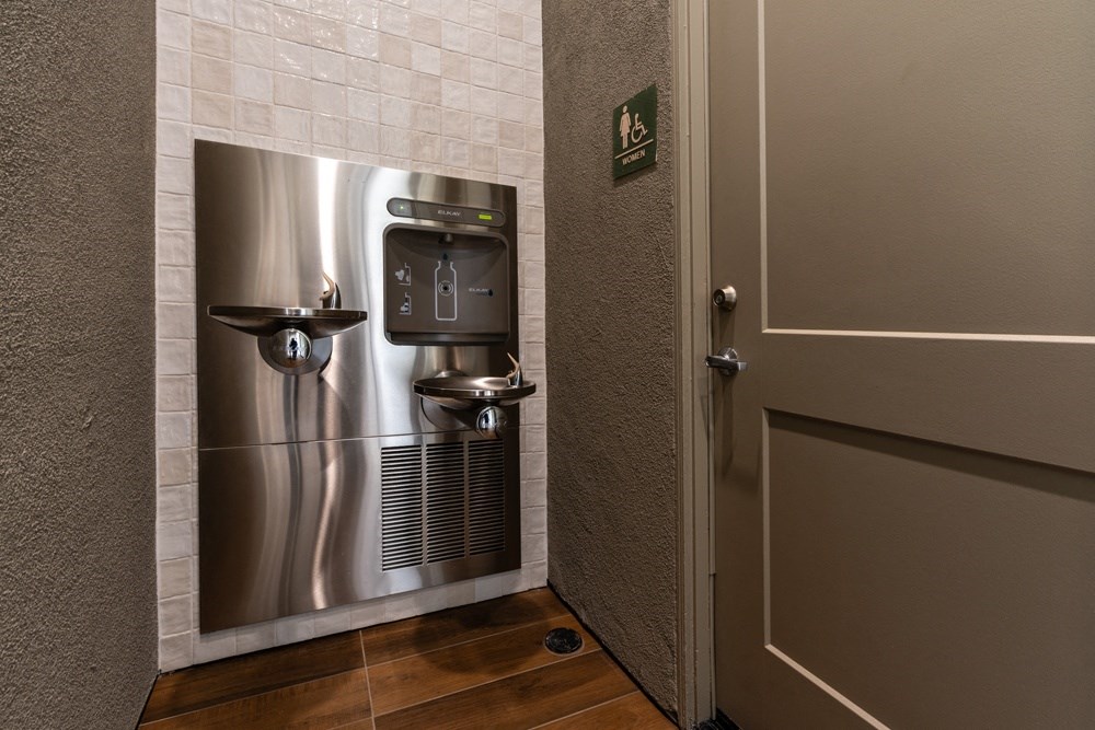 a stainless steel refrigerator in a bathroom with a door