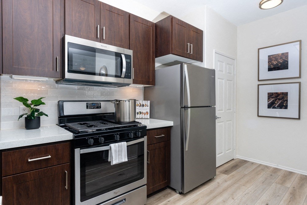 a kitchen with stainless steel appliances and wooden cabinets