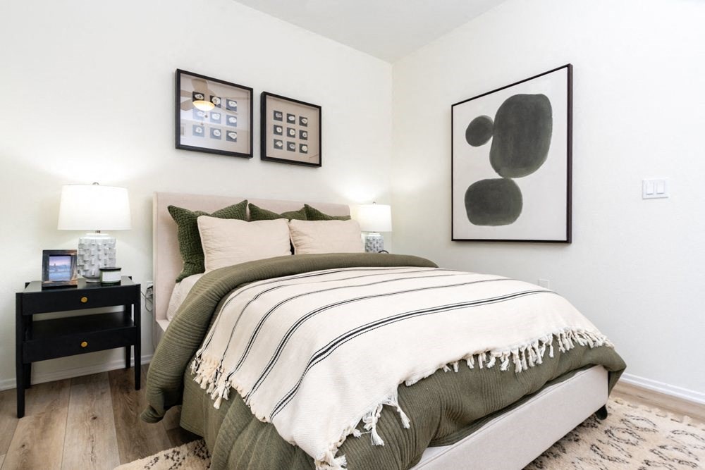 a bedroom with a bed and pictures on the wall