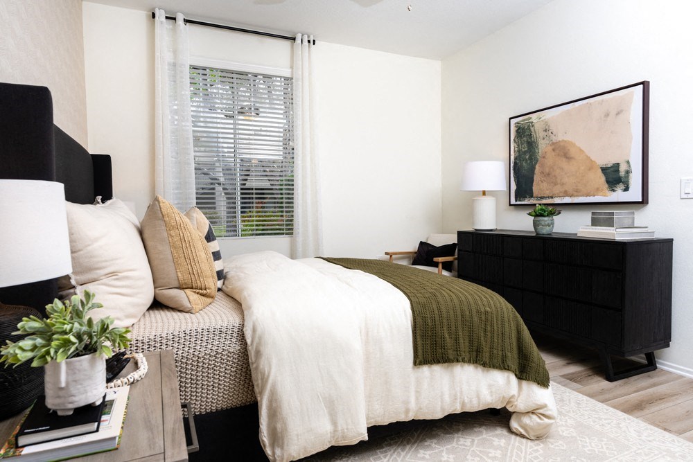 a bedroom with a bed and a dresser and a window