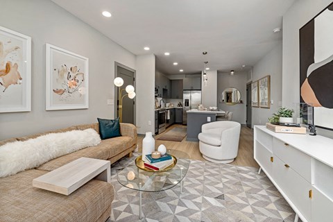 A modern living room with a white couch and a glass coffee table.